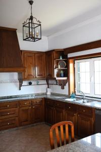 a kitchen with wooden cabinets and a chandelier at Casa da presa in Ponte de Lima