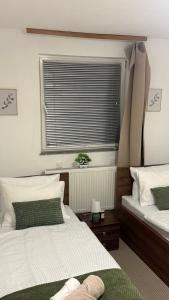 a bedroom with two twin beds and a window at The Nook Apartment in Jesenice +1 photo