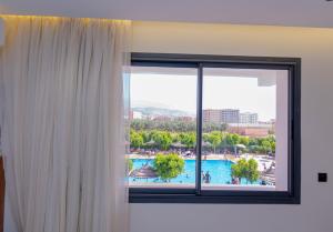 ein Fenster mit Blick auf ein Schwimmbecken in der Unterkunft Hotel Hamzaoui in Beni Mellal