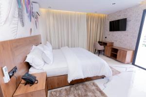 ein Schlafzimmer mit Bett, Schreibtisch und Fernseher in der Unterkunft Hotel Hamzaoui in Beni Mellal
