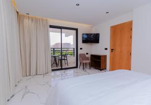 ein weißes Schlafzimmer mit Bett und Balkon in der Unterkunft Hotel Hamzaoui in Beni Mellal + 63 Fotos