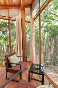 a screened in porch with a chair and a table at Tití Bungalows in Tarapoto