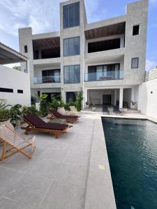 a building with a swimming pool and some chairs at Keur Noflaye Ngaparou in Mbour