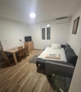 a living room with a bed and a desk at Nido Apartman in Kotor +7 photos