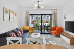 a living room with a blue couch and orange chairs at Marassi in El Alamein