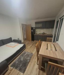 a room with a bed and a table and a kitchen at Nido Apartman in Kotor