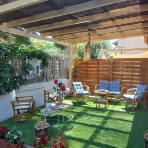 a patio with chairs and tables and a fence at Boheme studio Artemis in Áyios Spirídhon