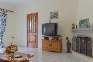 a living room with a tv and a fireplace at Akivillas Armação Pera Ocean II in Armação de Pêra
