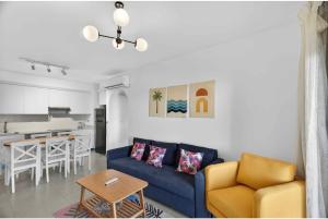 a living room with a blue couch and a table at Marassi in El Alamein