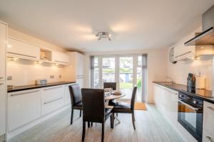 a kitchen with white cabinets and a table and chairs at 2 Bed in Portpatrick oc-p43756 in Portpatrick