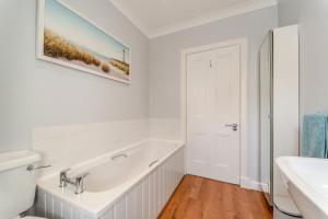 a white bathroom with a sink and a bath tub at 4 Bed in Portpatrick oc-p43755 in Portpatrick +24 photos