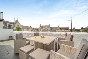 a patio with a table and chairs on a roof at 4 Bed in Portpatrick oc-p43755 in Portpatrick