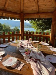 a wooden table with plates and napkins on it at Villa Tara in Gostivar +5 photos