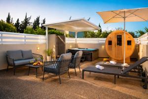 a patio with chairs and a pool table and an umbrella at BluWave Luxury Patio Spa Apartment Protaras Riviera in Paralimni