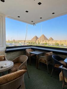 a restaurant with tables and chairs and a large window at New White Pyramids Inn in Cairo