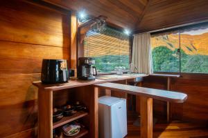 a kitchen with a counter and a sink and a window at Pousada Casa da Trilha in Vale do Capao