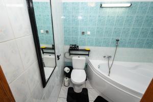a bathroom with a tub and a toilet and a sink at Pod lasem in Górowo Iławeckie