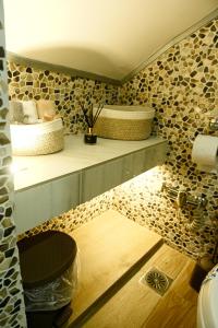 a bathroom with wooden floors and two shelves with towels at George's Stonehouse in Samos +28 photos