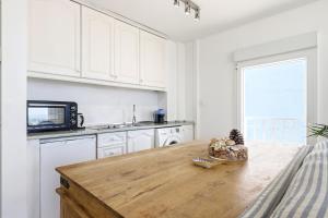 a kitchen with white cabinets and a wooden table at Puerto Banus Harbour View Apartment in Marbella +31 photos