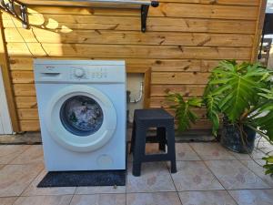 a washing machine with a stool next to a wall at Heaven Peace HUMILITY in La Trinité