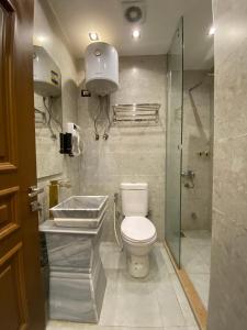 a bathroom with a toilet and a glass shower at New White Pyramids Inn in Cairo +73 photos