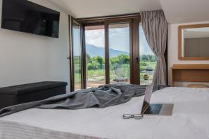 a bedroom with a bed with a laptop and glasses on it at Zeusplace Olympus Casa in Paralía Skotínis +85 photos