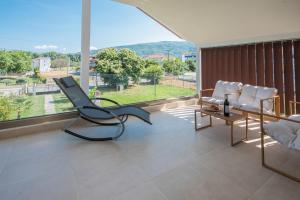 a living room filled with furniture and a large window at Zeusplace Olympus Casa in Paralía Skotínis