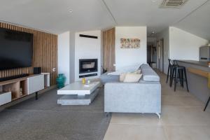 a living room with a couch and a flat screen tv at Zeusplace Olympus Casa in Paralía Skotínis