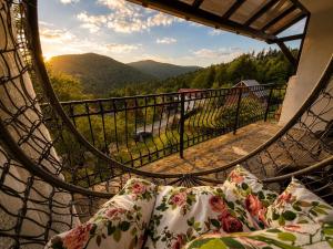 a bed with pillows on a balcony with a view at Vila Iepurasul Sinaia in Sinaia