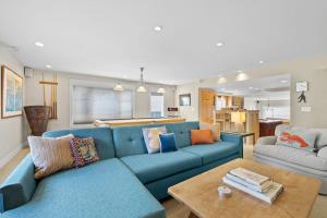 a living room with a blue couch and a table at Sand Side Bliss in Oxnard