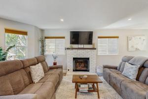 a living room with two couches and a fireplace at Wanderlust Cambria Seaside Village in Cambria