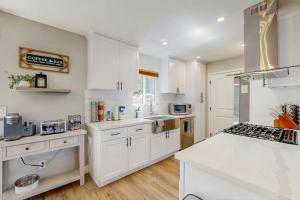 a kitchen with white cabinets and a white counter top at Wanderlust Cambria Seaside Village in Cambria +14 photos