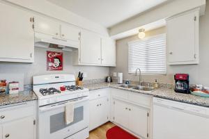 a kitchen with white cabinets and a stove top oven at Ramona Memories in Grover Beach
