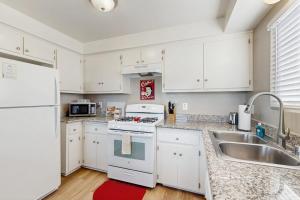 a kitchen with white cabinets and a sink at Ramona Memories in Grover Beach