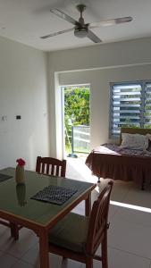 a living room with a bed and a table and chairs at Sunview in Savusavu