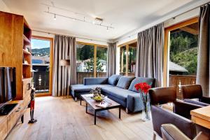 a living room with a blue couch and a tv at Gerlos Mountain Estate in Gerlos