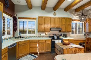 a kitchen with wooden cabinets and a stove top oven at Cereus Vista in Tucson +18 photos