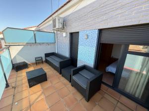 an outdoor patio with two chairs and a balcony at SEGEDA 3 APARTAMENTOS Turísticos in Calatayud