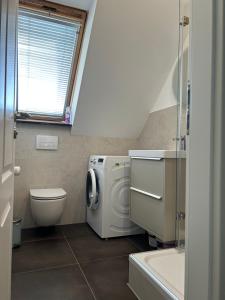 a bathroom with a washing machine and a toilet at Ferienwohnung am Uniklinik in Lübeck +40 photos
