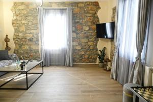 a living room with a stone wall and a window at George's Stonehouse in Samos