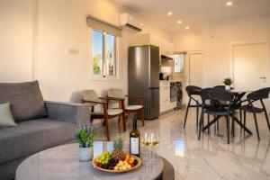 a living room with a couch and a table with a bowl of fruit at BluWave Luxury Patio Spa Apartment Protaras Riviera in Paralimni