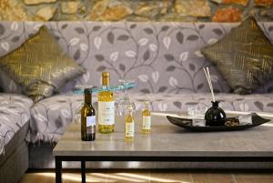 a table with bottles of wine on it with a couch at George's Stonehouse in Samos