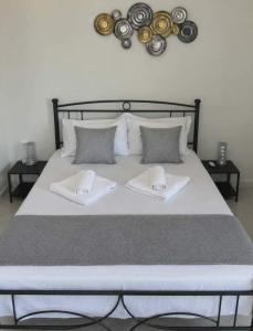 a large bed with two white towels on it at George's Stonehouse in Samos