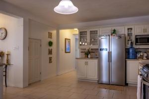 a kitchen with a stainless steel refrigerator and white cabinets at Carmich Place in Saint Johnʼs