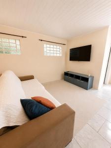 a bedroom with a bed and a flat screen tv at Farol House in Pântano Grande
