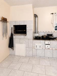 a kitchen with a stove and a tiled floor at Farol House in Pântano Grande