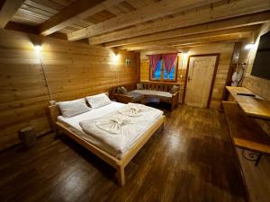 a bedroom with a bed in a wooden room at Lagano Mountain Retreat - Via Ferrata & Restaurant in Gusinje