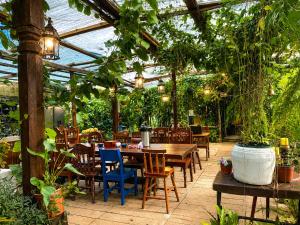 eine Terrasse mit Tisch und Stühlen unter einem Gewächshaus in der Unterkunft Kakao Lodge & Garden Río Celeste in Bijagua