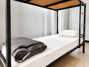 a black bunk bed with white sheets and a blanket at Hi Hostels Shillong in Shillong +3 photos