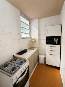 a kitchen with a stove and a white refrigerator at Apartamento em Botafogo 5 min de Copacabana in Rio de Janeiro +9 photos